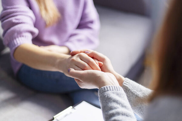 Крупный план женщины-психолога, держащей женщину за руки во время сеанса терапии. Психотерапевт, поддерживающий ее пациента в депрессии.