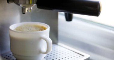 Kahve espresso ya da kahve makinesinde rigerto yapmak. Evde sıcak espresso yapıyorum. Köpüklü kahve. Beyaz bardakta espresso. Kahvaltıda içecek.