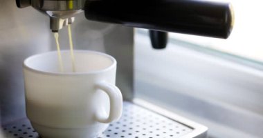 Kahve espresso ya da kahve makinesinde rigerto yapmak. Evde sıcak espresso yapıyorum. Köpüklü kahve. Beyaz bardakta espresso. Kahvaltıda içecek.