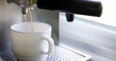 Kahve espresso ya da kahve makinesinde rigerto yapmak. Evde sıcak espresso yapıyorum. Köpüklü kahve. Beyaz bardakta espresso. Kahvaltıda içecek.