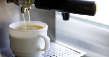 Kahve espresso ya da kahve makinesinde rigerto yapmak. Evde sıcak espresso yapıyorum. Köpüklü kahve. Beyaz bardakta espresso. Kahvaltıda içecek.