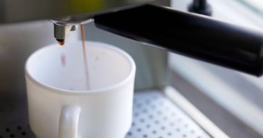 Kahve espresso ya da kahve makinesinde rigerto yapmak. Evde sıcak espresso yapıyorum. Köpüklü kahve. Beyaz bardakta espresso. Kahvaltıda içecek.
