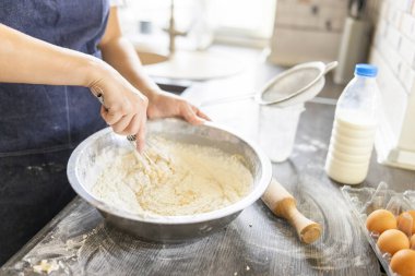 Pişirme konsepti. Mutfakta ev yapımı hamur işleri için hamur yoğuran önlüklü kadın..