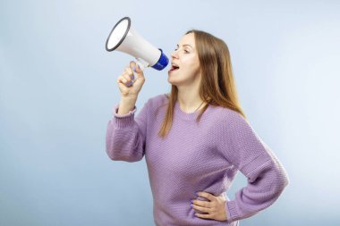 Mavi arka planda elinde megafonla bağıran esmer bir kadın. Konuşma ve duyuru kavramı, pazarlama veya satış fikri.