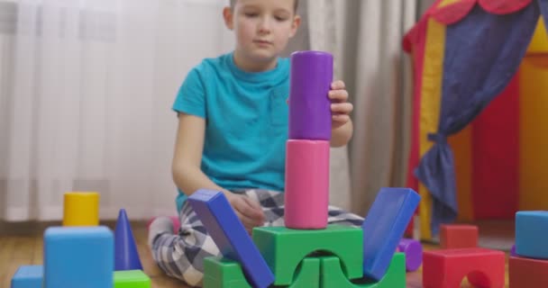 一个孩子在地板上和孩子们玩积木 建造一个立方体塔 儿童教育玩具 — 图库视频影像