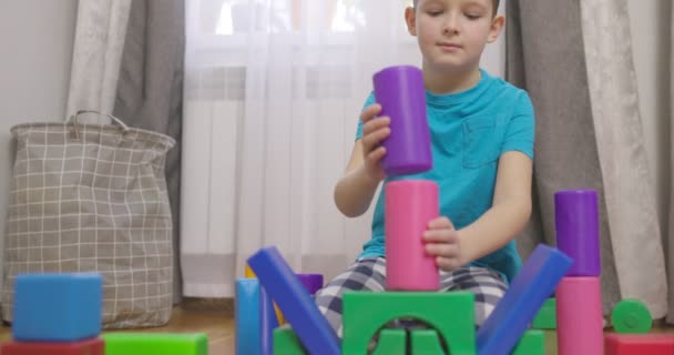 一个孩子在地板上和孩子们玩积木 建造一个立方体塔 儿童教育玩具 — 图库视频影像