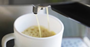 Kahve espresso ya da kahve makinesinde rigerto yapmak. Evde sıcak espresso yapıyorum. Köpüklü kahve. Beyaz bardakta espresso. Kahvaltıda içecek..