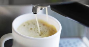 Kahve espresso ya da kahve makinesinde rigerto yapmak. Evde sıcak espresso yapıyorum. Köpüklü kahve. Beyaz bardakta espresso. Kahvaltıda içecek..