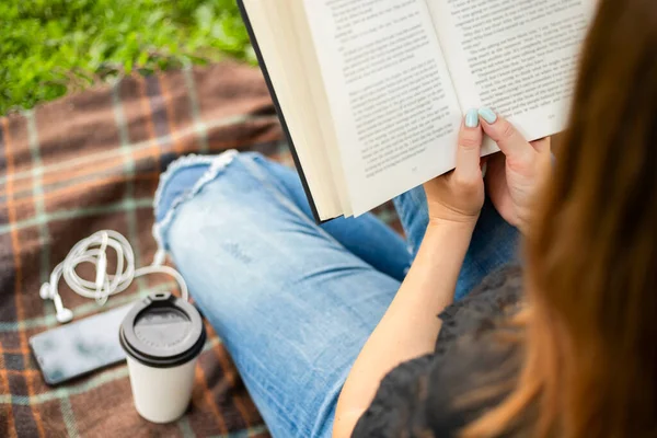 Een Vrouw Spijkerbroek Met Kopje Koffie Lezen Boek Terwijl Zitten — Stockfoto