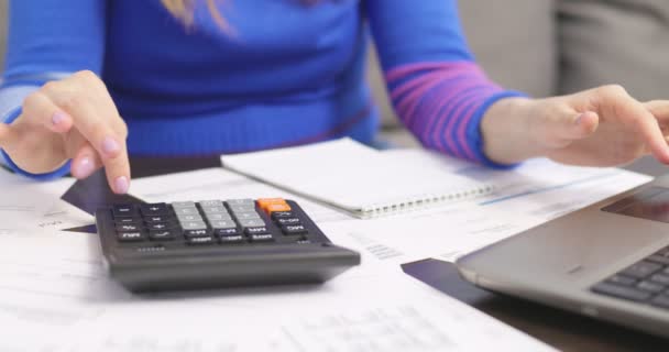 Женщина Помощью Калькулятора Рассчитывает Домашние Счета Дома Делает Бумажную Работу — стоковое видео
