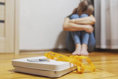 Beyaz tartı ve depresyon, üzgün ve üzgün kadın ahşap zeminde mezura ile.