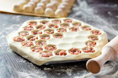 Ev yapımı hamur tatlısı yapma süreci. Hamur köfteleri hazırlama süreci masada hamur, merdane ve hazır hamur köfteleriyle..