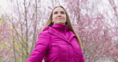 Calm beautiful smiling young woman enjoying the fresh air in the park outdoors, relaxing , feeling alive, breathing, dreaming