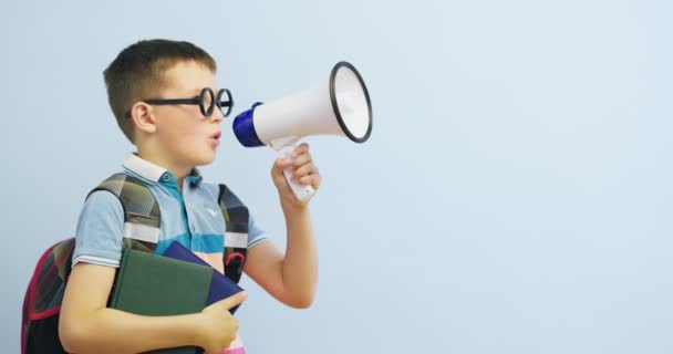 Kleine Schooljongen Met Megafoon Blauwe Achtergrond Jongen Met Megafoon Maakt — Stockvideo