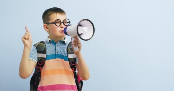 Kleine Schooljongen Met Megafoon Blauwe Achtergrond Jongen Met Megafoon Maakt — Stockvideo