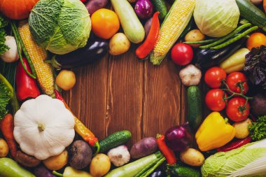 Healthy food background with copy space. Assortment of fresh vegetables on wooden background. Harvest of vegetables.