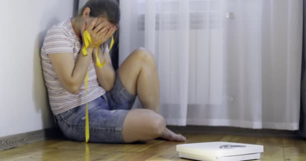 白いスケールとうつ病 木製の床に測定テープと動揺と悲しい女性 — ストック動画
