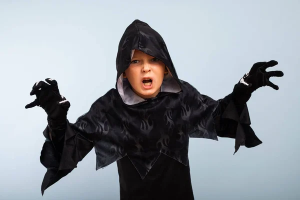 Happy Halloween! Portrait of an angry little boy in halloween costume with frightening gesture.