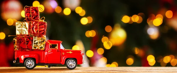 圣诞彩灯背景下的红色小复古玩具卡车的横幅照片 圣诞节 新年的概念 复制空间 — 图库照片