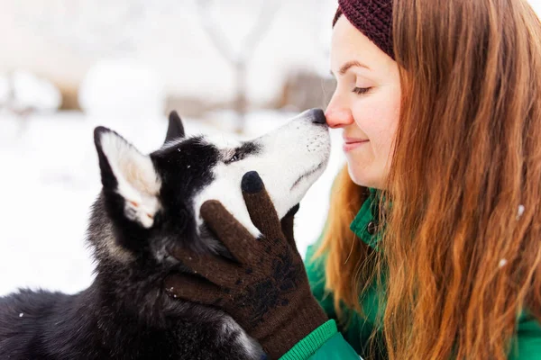 美しいです女性遊びとともに彼女の犬黒と白の空とともに青目屋外で冬 — ストック写真