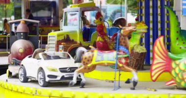 Küçük çocuk lunaparktaki atlıkarıncada eğleniyor. Yüksek kalite 4k görüntü