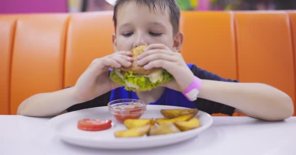 Criança Bonita Comendo Hambúrguer Grande Mesa Restaurante Fast Food Refeição — Vídeo de Stock