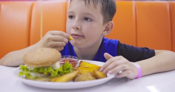 Bambino Mangiare Hamburger Patatine Fritte Ristorante Fast Food Bambino Immergendo — Video Stock