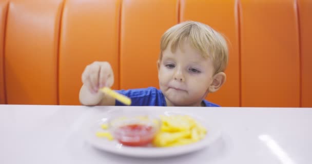 Criança Bonita Comendo Batatas Fritas Com Molho Tomate Mesa Restaurante — Vídeo de Stock