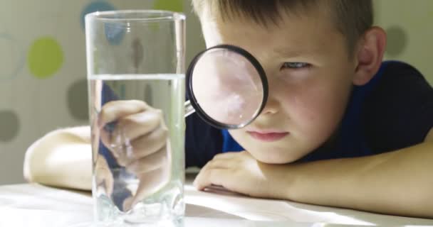 Het Jongetje Kijkt Naar Water Een Glas Door Vergrootglas Concept — Stockvideo