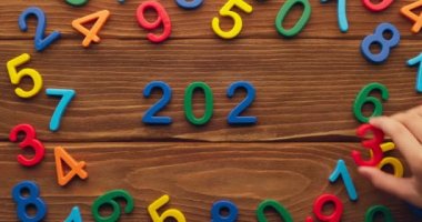 Çocuk eli, 2023 yılını tahta arka plana renkli numaralar koyarak geçirdi. Yüksek kalite 4k görüntü