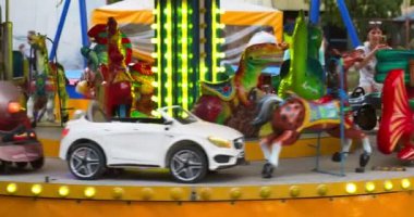 Zaporozhye, Ukrayna - 17 Ağustos 2022. Lunaparkta dönen renkli bir atlıkarınca. Eğlence endüstrisi konsepti. Yüksek kalite 4k görüntü