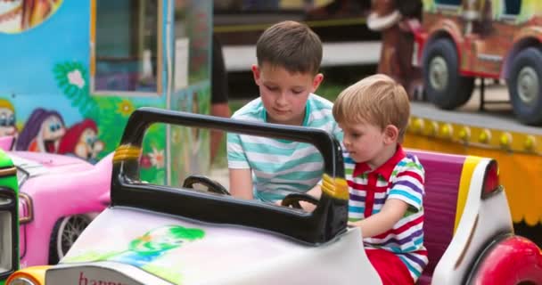 Twee Blije Kinderen Die Plezier Hebben Een Speelgoedauto Een Pretpark — Stockvideo