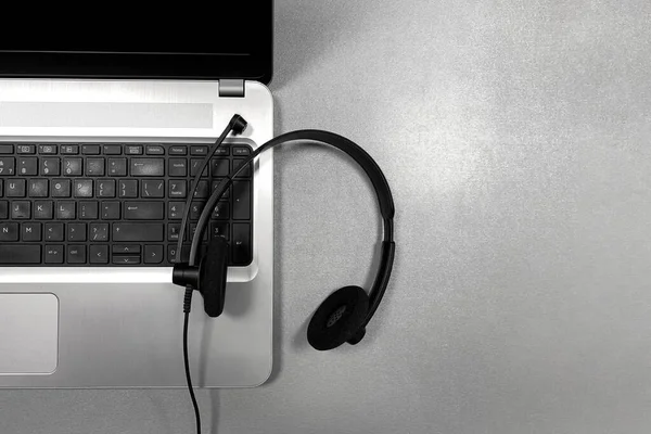 Szary Laptop Słuchawki Mikrofonem Szarej Błyszczącej Powierzchni Koncepcja Kształcenia Odległość — Zdjęcie stockowe