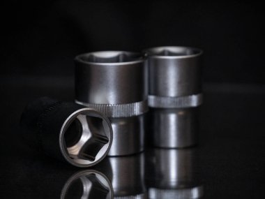 - İngiliz anahtarı. Parlak siyah yüzeyde paslanmaz çelik uğursuzluk yuvaları. Araba tamiri için evrensel profesyonel bir araç. Düşük tuşlu fotoğraf.