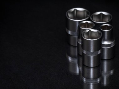 - İngiliz anahtarı. Parlak siyah yüzeyde paslanmaz çelik uğursuzluk yuvaları. Araba tamiri için evrensel profesyonel bir araç. Düşük tuşlu fotoğraf.