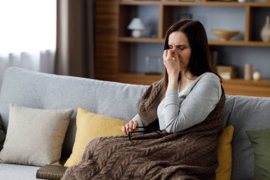 Gözlük takan genç bir kadın. Gözleri kapalı yorgun bir kadın. Gözlerine masaj yapıyor. Acı verici hisler veriyor..