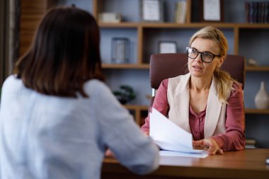 İş görüşmesi. Kadın İK müdürü genç adayla konuşuyor. İşveren ve başvuru sahibi ofis toplantısında stajyerlerin profesyonel özetini tartışıyor. İşe alım ve istihdam, işe alım konsepti.