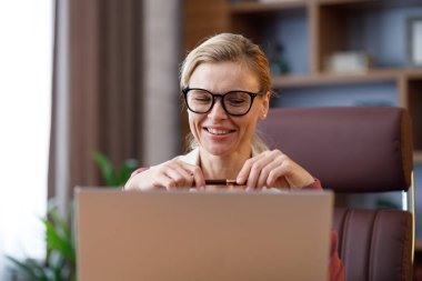 Ofiste dizüstü bilgisayarla çalışan güzel bir iş kadınının portresi. Mesajlaşmak, internete bakmak, online çalışmak, uzaktan çalışmak. İş konsepti. Modern başarılı kadın liderin portresi.