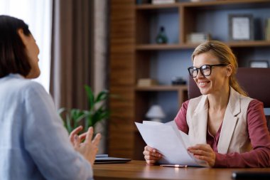 İş görüşmesi. Kadın İK müdürü genç adayla konuşuyor. İşveren ve başvuru sahibi ofis toplantısında stajyerlerin profesyonel özetini tartışıyor. İşe alım ve istihdam, işe alım konsepti.
