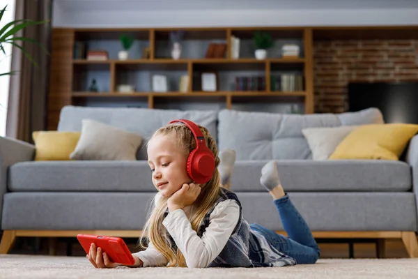 Little Girl Wearing Red Earphones Lying Carpet Home Cute Smiling —  Fotos de Stock