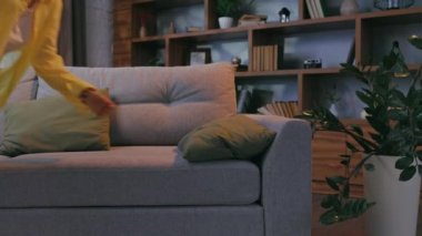 Tired curly girl falls down while sitting on the couch feeling apathy. Feeling depressed, lack of motivation, sadness, boredom. Exhausted, she collapses on the couch from stress