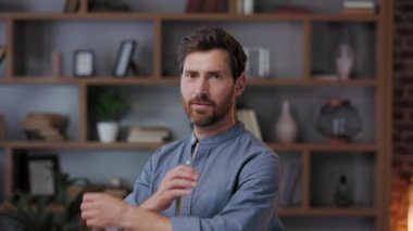 Gülümseyen sakallı, bin yıllık profesyonel iş adamı kameraya bakıyor. Yakın plan iş portresi. Yakışıklı yetişkin girişimci. Ofiste gülümseyerek poz veren müdür.