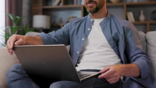 Bonito Homem Trabalhando Laptop Enquanto Sentado Sofá Apartamento Elegante Relaxe — Vídeo de Stock