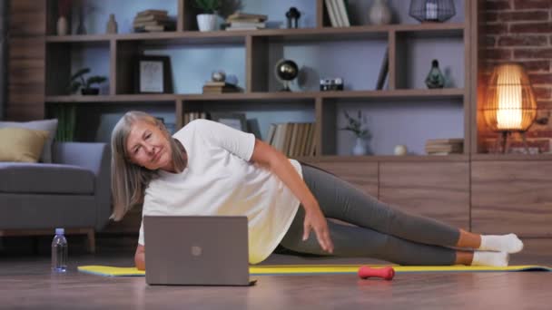 Gri Saçlı Mutlu Olgun Bir Kadın Evde Dizüstü Bilgisayarla Jimnastik — Stok video