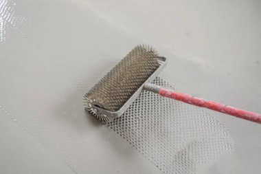 Döşeme kaplaması sırasında alçı, kendi seviyesini yükselten çimento harcı ile çalışır, iğne silindiri kullanır