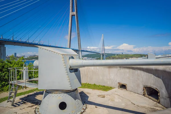 Gun of coastal batterie in Vladivostok fortress and Cable-stayed bridge. Island of Russian, Vladivostok, Russia — Stock Photo, Image