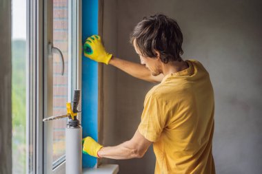 İnşaatçı veya tamirci pencerelerin onarımı veya kurulumu ile meşguldür