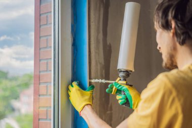 İnşaatçı veya tamirci pencerelerin onarımı veya kurulumu ile meşguldür