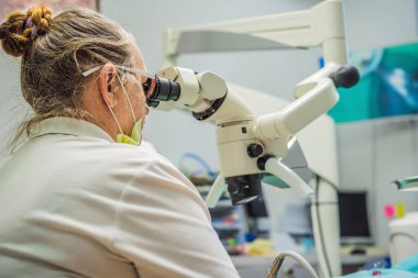 Mikroskopla diş tedavisi. Diş hekimlerine muayene olan bir adam. Dişçide randevum var. Yaşam tarzı, gerçek hayat.