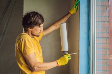 İnşaatçı veya tamirci pencerelerin onarımı veya kurulumu ile meşguldür